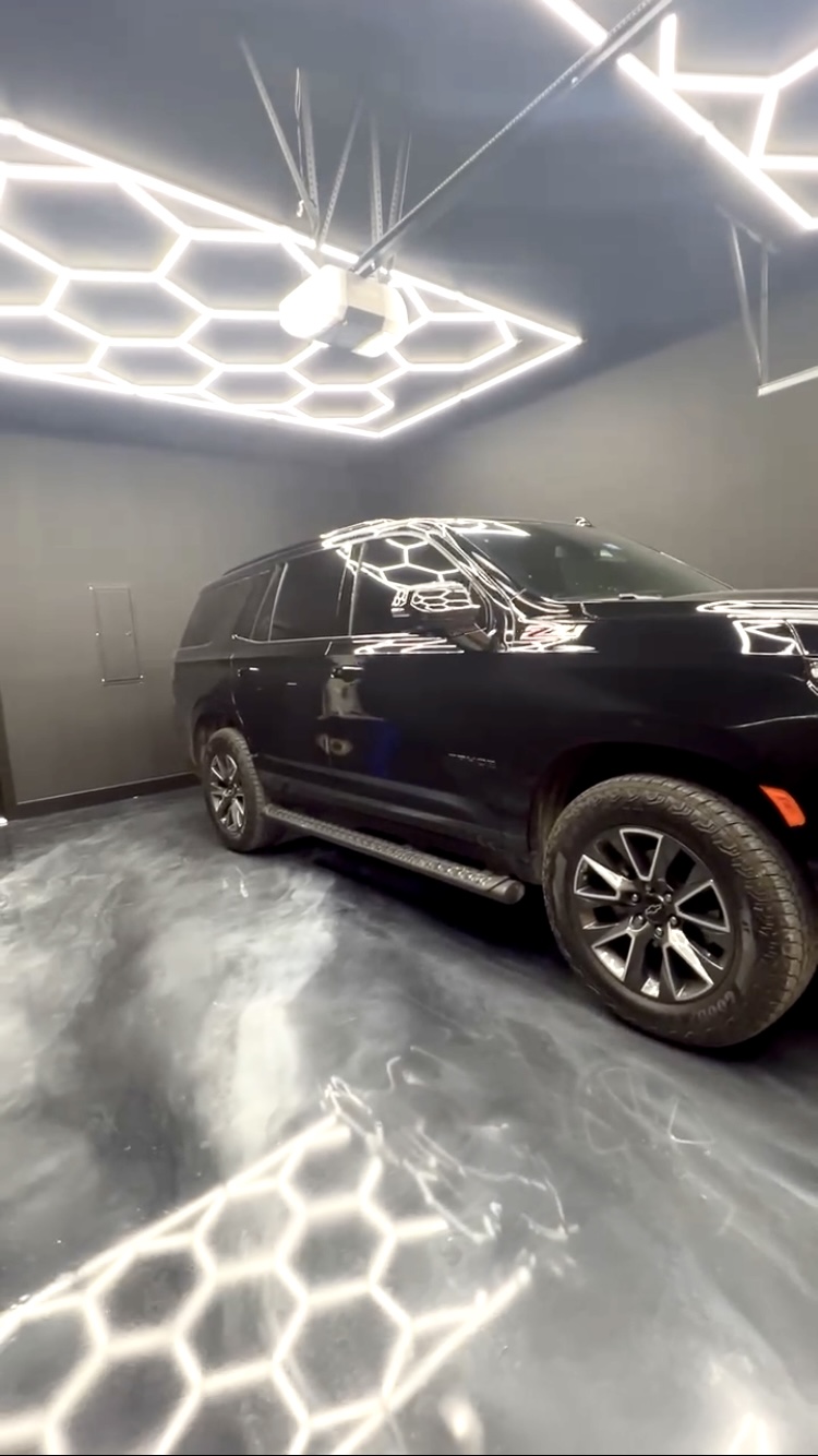 Luxury metallic epoxy floor with marble effect in garage with hex lights by Carpenter Coating